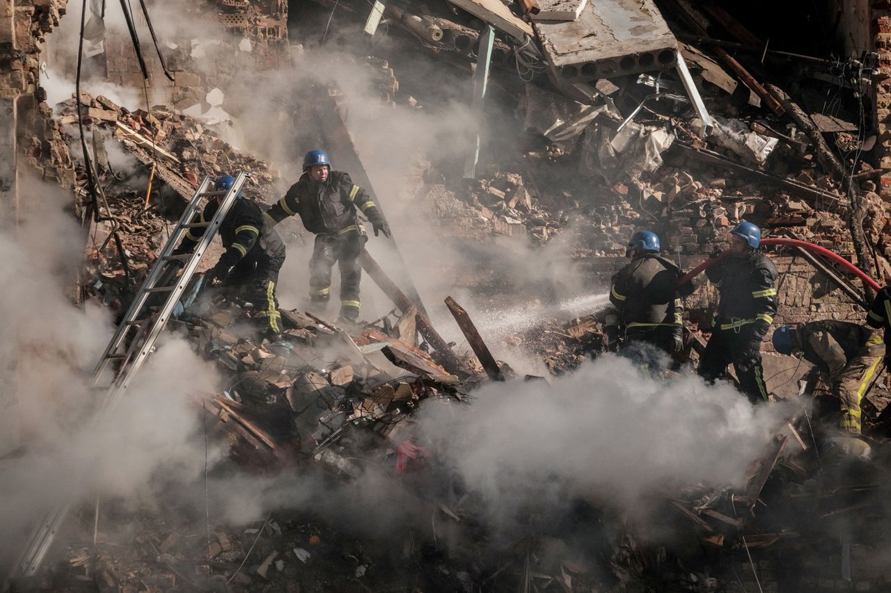 Ukrainian firefighters search a destroyed building after a drone attack in Kyiv on October 17.