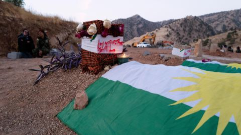Tumbas recién excavadas cubiertas con la bandera nacionalista kurda donde descansan seis de los ocho militantes que murieron en el ataque iraní del 28 de septiembre.  Dos de los cuerpos aún no han sido recuperados.