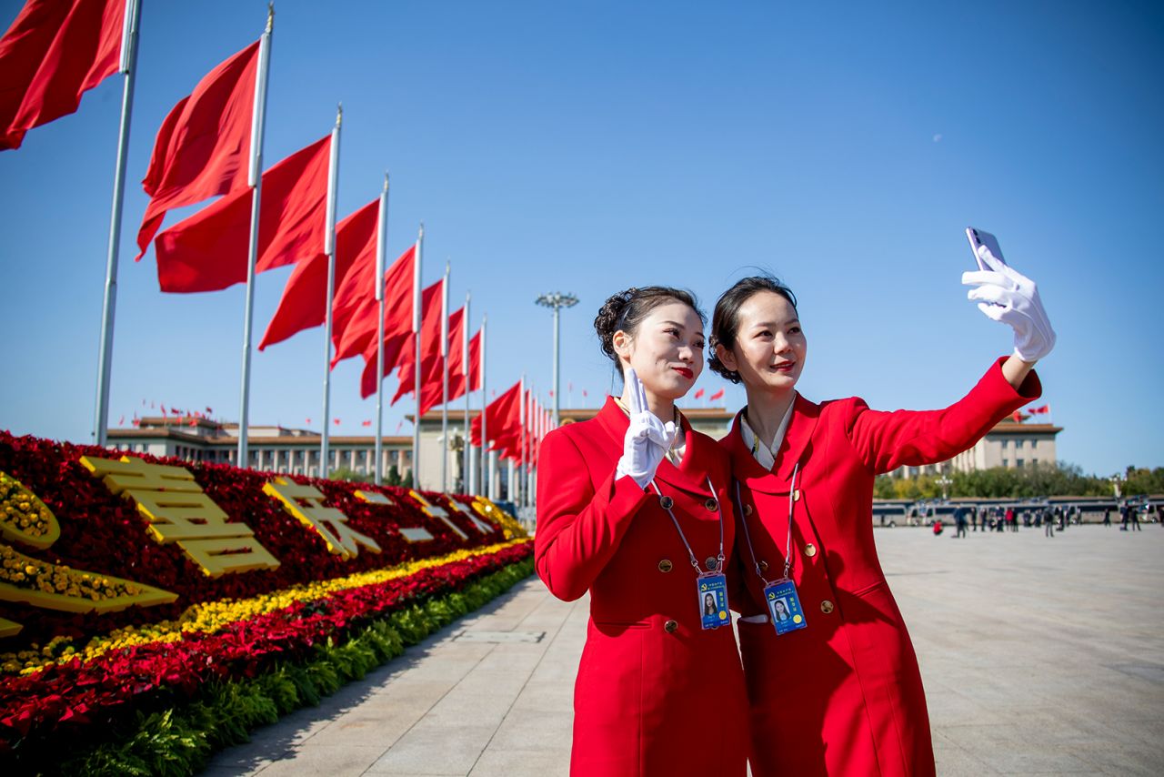 Volunteers take a selfie outside the Great Hall of the People.