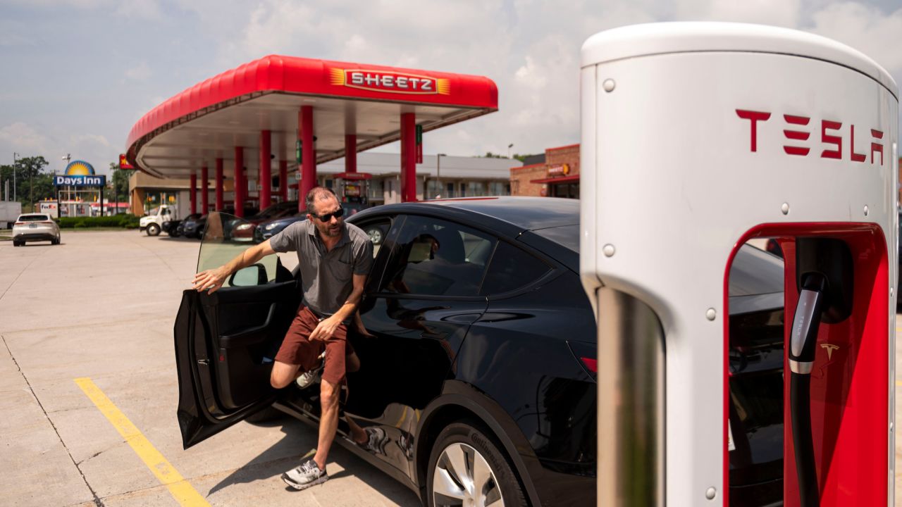 A driver stops at a Tesla charging station at a Sheetz.