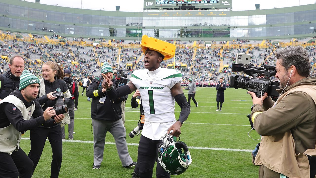 Sauce Gardner of the New York Jets celebrates after beating the Green Bay Packers wearing a cheesehead hat -- a traditional accessory for Packers fans.