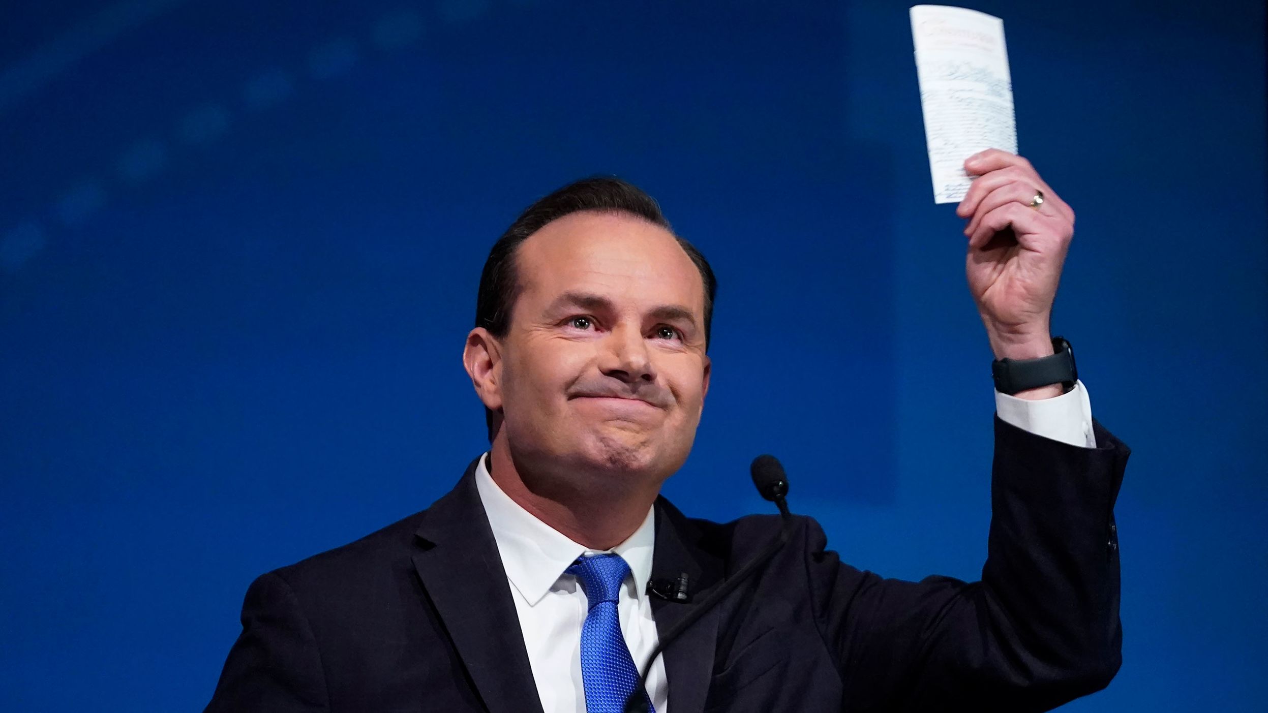 Utah Republican Sen. Mike Lee holds his pocket Constitution of the United States during a televised debate with his independent challenger Evan McMullin on Monday, Oct. 17, 2022, in Orem, Utah.