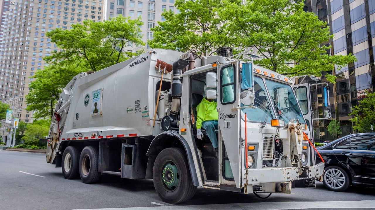 A garbage truck is pictured driving around Manhattan.
