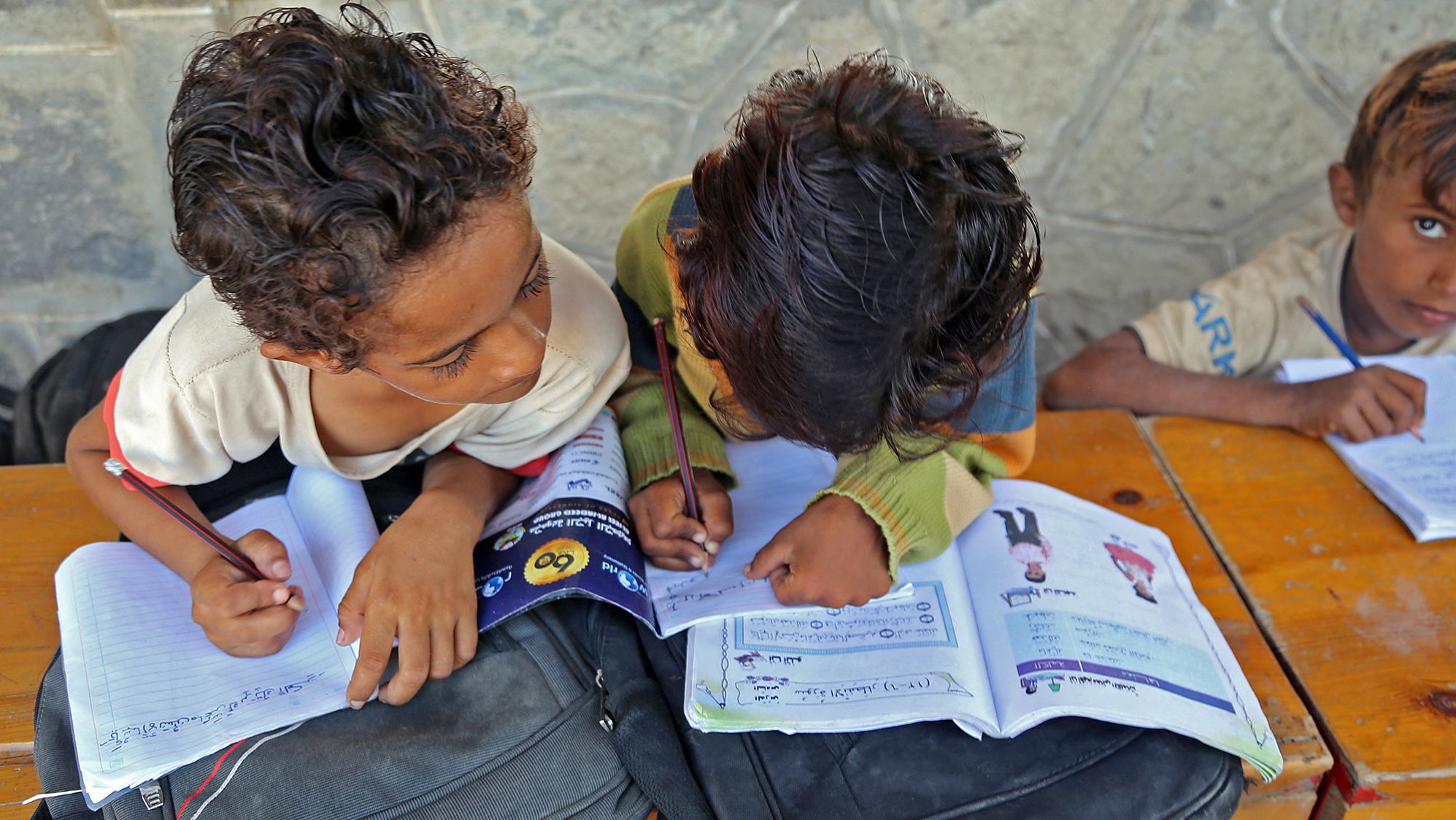 Yemeni children attend class outdoors in a heavily-damaged school on the first day of the new academic year in Yemen's war-torn western province of Hodeida on Monday. 