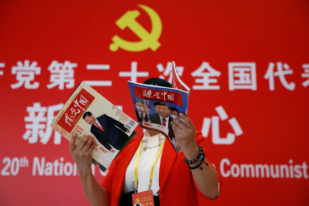 A journalist at a hotel in Beijing on October 19 holds magazines with images of leader Xi Jinping on the covers.