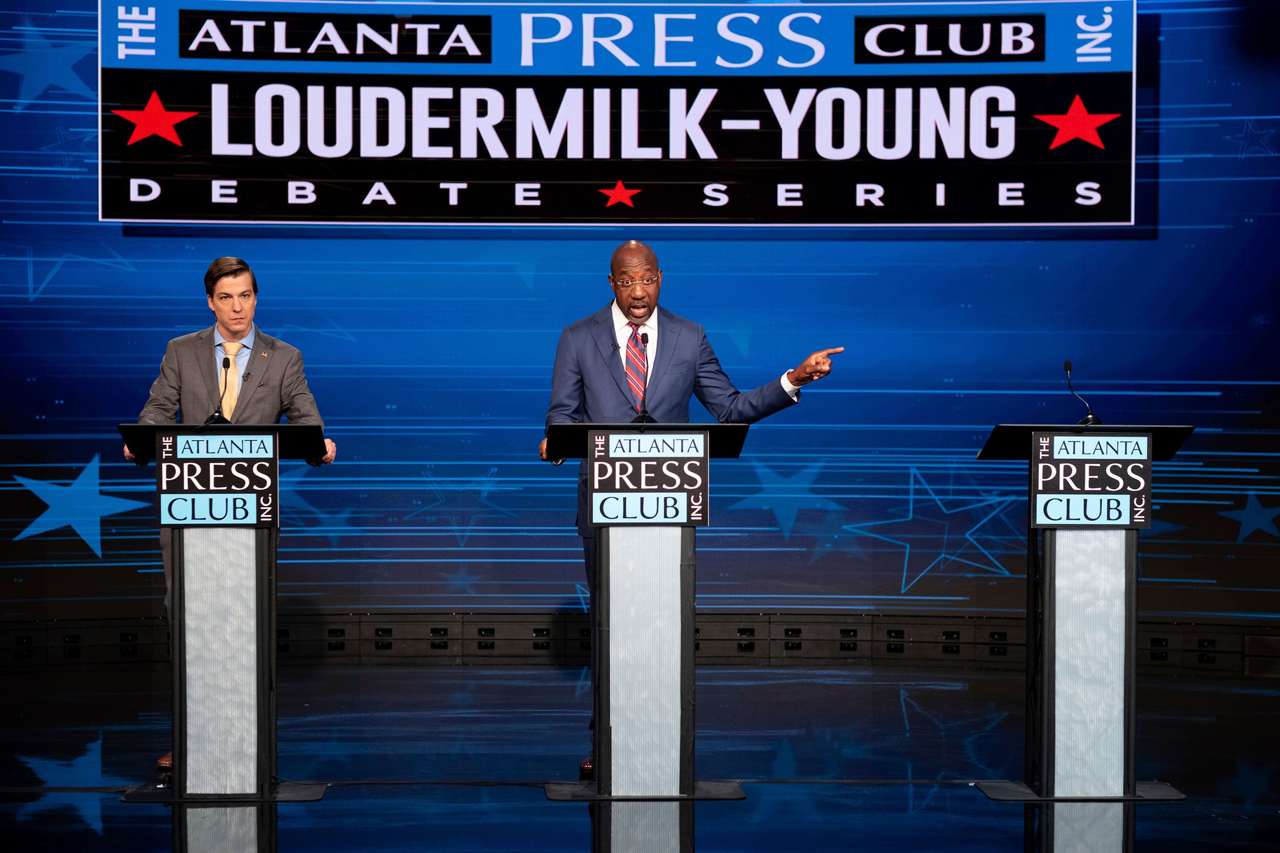 Democratic Sen. Raphael Warnock gestures next to an empty podium set up for Republican challenger Herschel Walker during a Senate debate in Atlanta on Sunday, October 16.