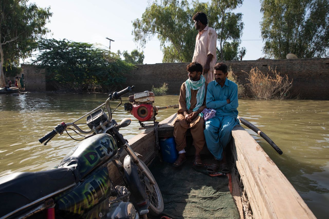 People ride in boats across floodwaters in Dadu, Pakistan, on Tuesday, October 18. Last month, authorities in Pakistan <a href=