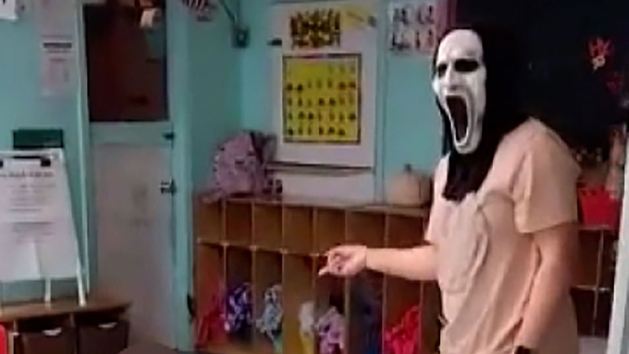 An adult wearing a "Scream"-style mask is seen yelling at and chasing children in the video. 