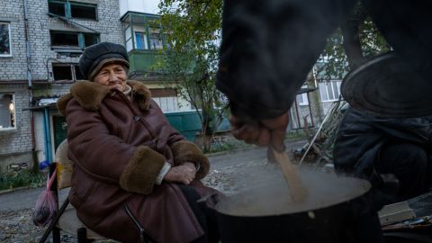 Civilians cook on fire outside of their homes after gas lines were destroyed in Lyman in October 2022.