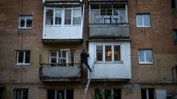 A man repairs his balcony on a building damaged by fighting between Ukrainian and Russian forces in Borodyanka, Kyiv region, Ukraine, Thursday, Oct. 20, 2022. Airstrikes cut power and water supplies to hundreds of thousands of Ukrainians on Tuesday, part of what the country's president called an expanding Russian campaign to drive the nation into the cold and dark and make peace talks impossible. (AP Photo/Emilio Morenatti)