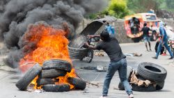 Protesters put up barricades made with burning tires in support of police officers not far from the airport junction in Port-au-Prince on September 14, 2020. - Hundreds of protesting Haitian police officers and their supporters, many of them armed and wearing masks, sparked panic in the capital Port-au-Prince on September 14, setting cars on fire as they voiced their anger at the ruling party.
The cops have demanded higher salaries and the release of a colleague -- a member of the narcotics squad has been held since early May on suspicion of murder, arson and destruction of public property. (Photo by Reginald LOUISSAINT JR / AFP) (Photo by REGINALD LOUISSAINT JR/AFP via Getty Images)