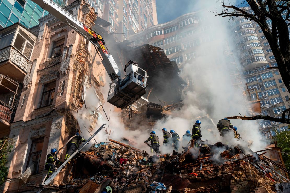 Firefighters work after a drone attack on buildings in Kyiv on October 17, 2022.
