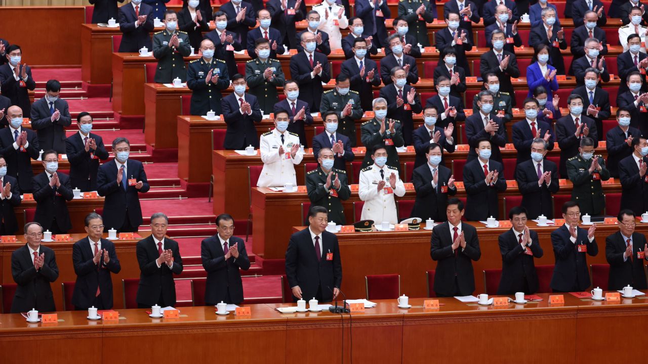 Chinese leaders and delegates applaud at the closing ceremony.