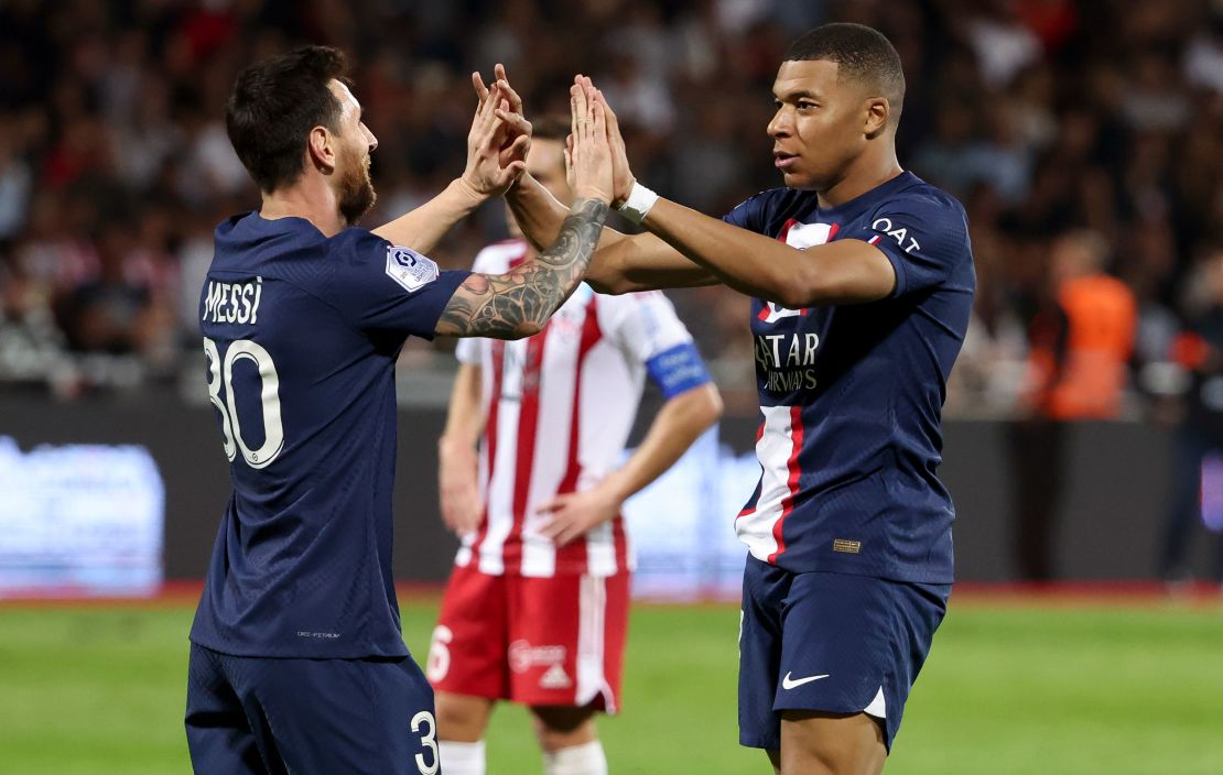 Kylian Mbappe celebrates with Lionel Messi.
