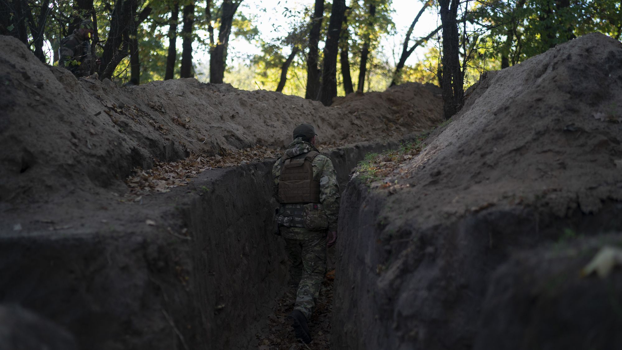 A Ukrainian soldier checks a trench dug by Russian soldiers in a retaken area of the Kherson region on October 12.