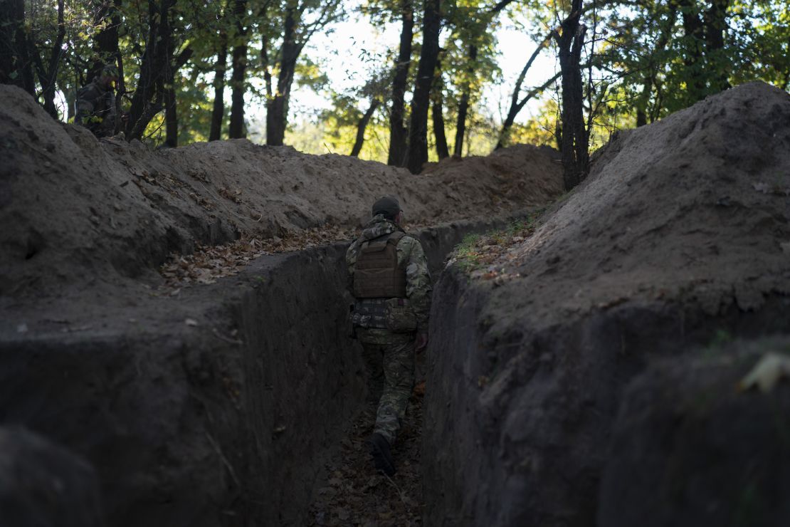 A Ukrainian soldier checks a trench dug by Russian soldiers in a retaken area of the Kherson region on October 12.
