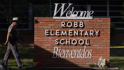 An officer walks outside Robb Elementary School in Uvalde, Texas, where 19 children and two teachers were killed in a shooting in May.