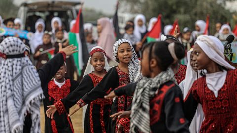 Palestinian girls wearing traditional embroidered dresses perform during a ceremony marking the start of the olive harvest season in Deir al-Balah in central Gaza on Sunday.  