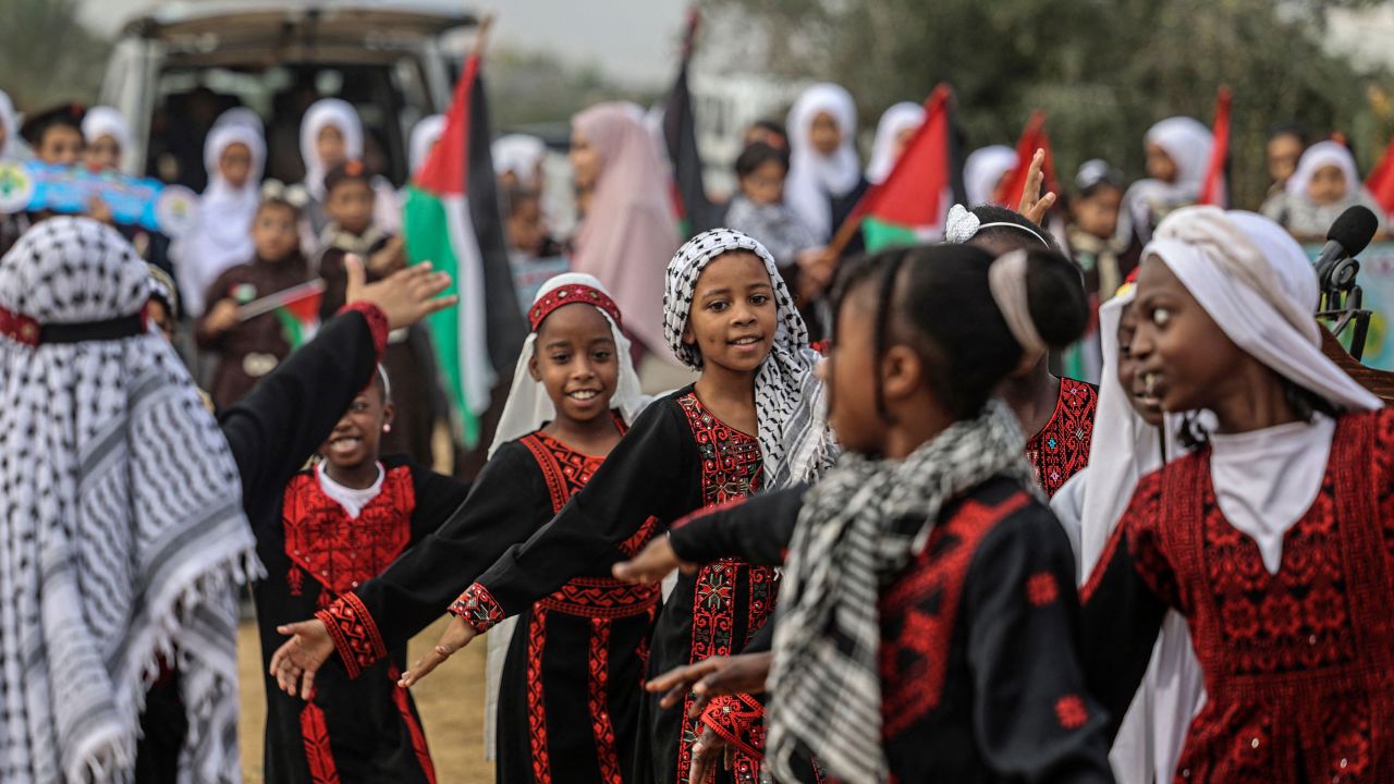 Palestinian girls wearing traditional embroidered dresses perform during a ceremony marking the start of the olive harvest season in Deir al-Balah in central Gaza on Sunday.  