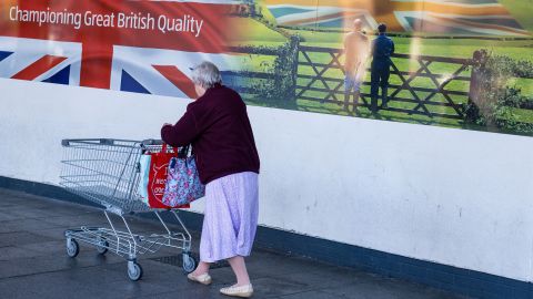 A customer pushes a shopping cart into an Aldi supermarket in Sheffield on Saturday, Oct. 15.