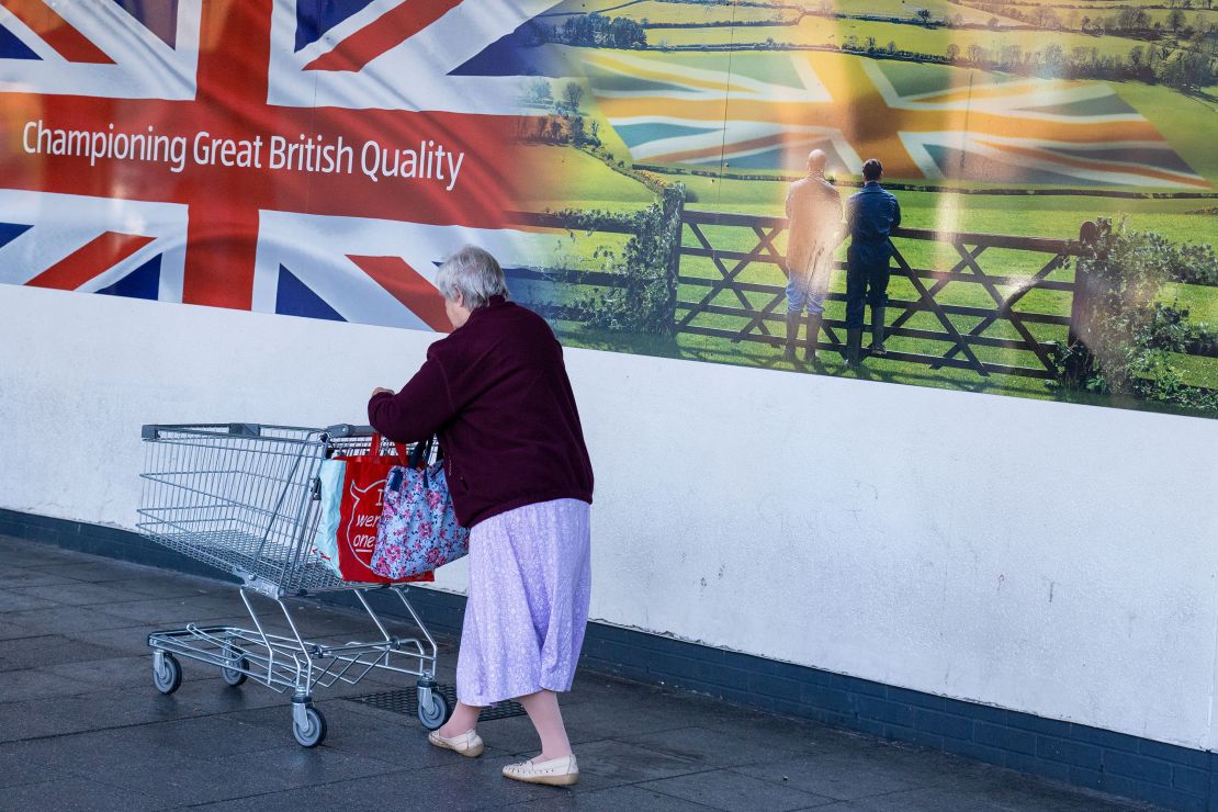 A customer pushes a shopping cart into an Aldi supermarket in Sheffield on Saturday, Oct. 15.