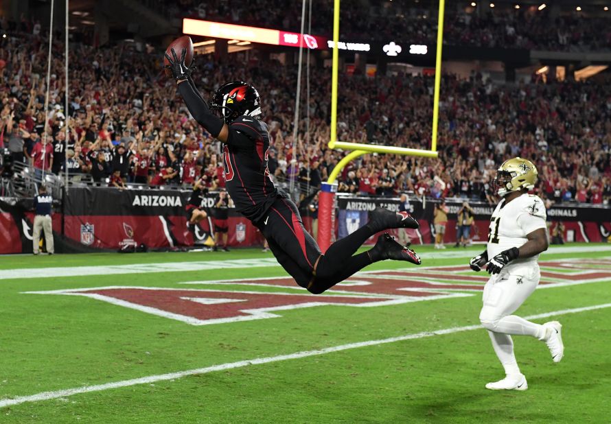 Arizona Cardinals cornerback Marco Wilson leaps into the end zone as he returns an interception for a touchdown during a Thursday Night Football football game against the New Orleans Saints. The Arizona defense scored touchdowns on two pick-sixes late in the first half.