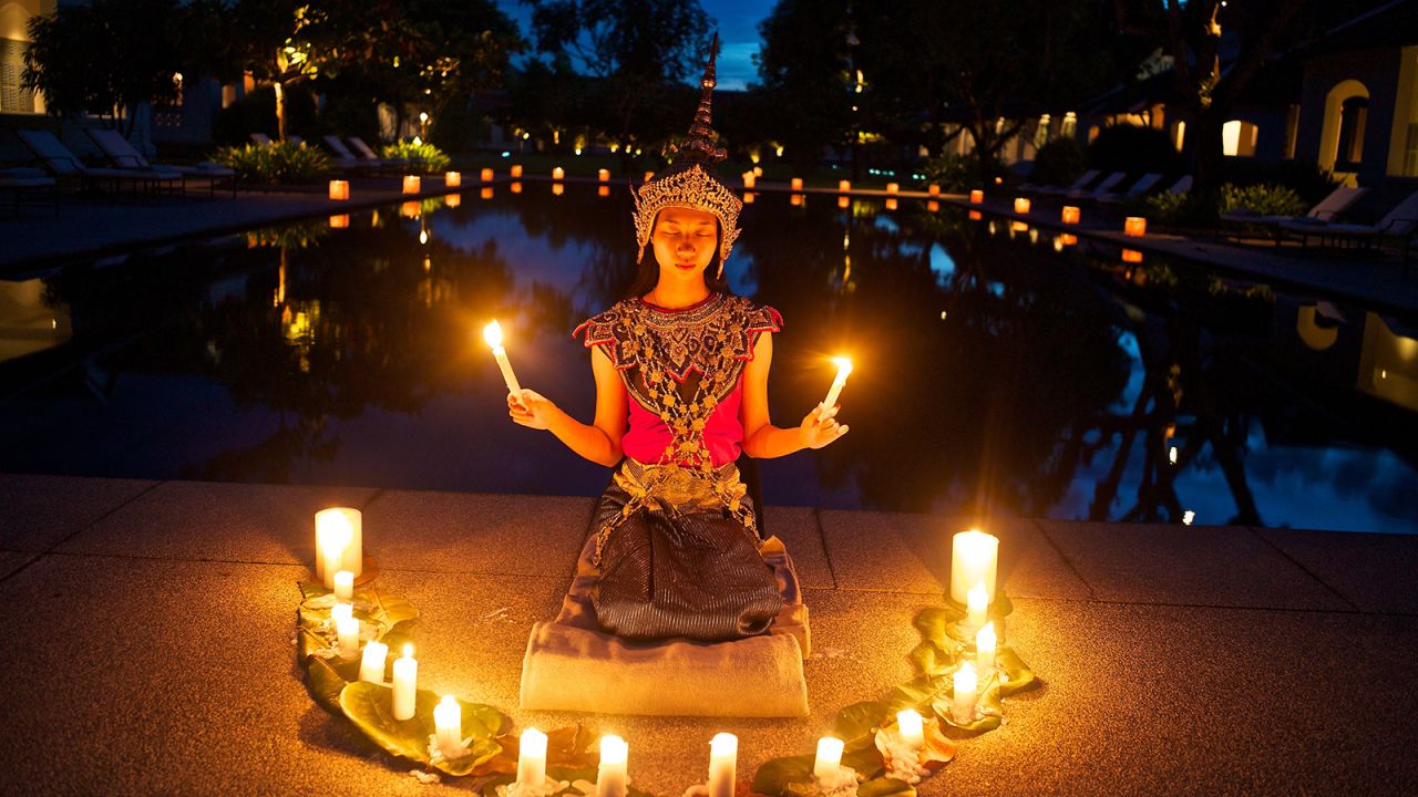 <strong>Laos: </strong>Candles surround a young nang keo dancer in Luang Prabang, Laos's former imperial capital that is now reachable by bullet train. The train is making Laos more accessible to tourists and bringing economic opportunities to locals.