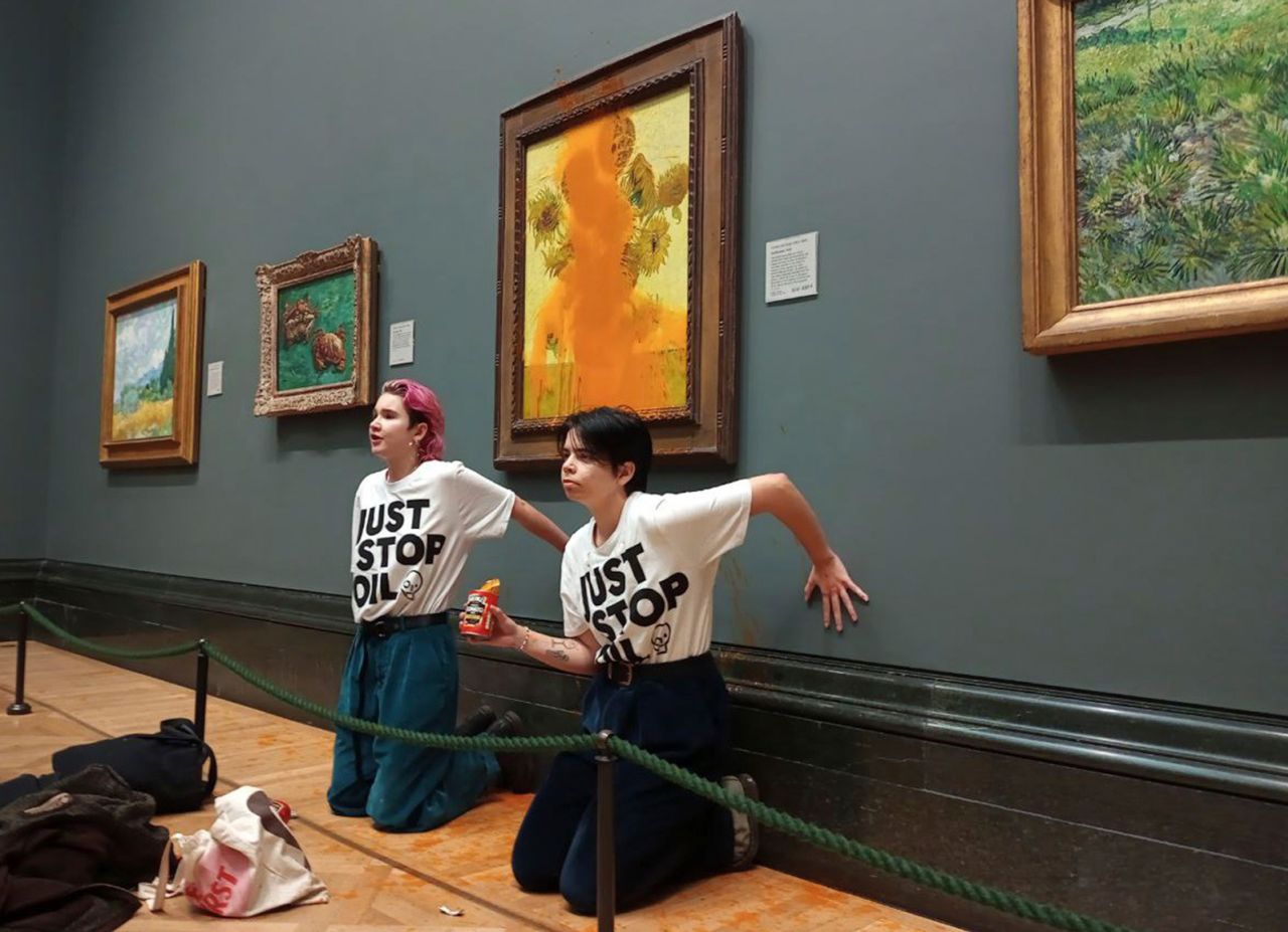 Handout photo issued by Just Stop Oil of two protesters who threw tinned soup at Vincent van Gogh's "Sunflowers" at the National Gallery in London on October 14