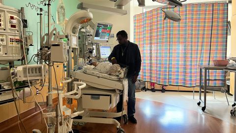 Stephen Balka stands over his son Adrian, who is hospitalized at Texas Children's Hospital with RSV.