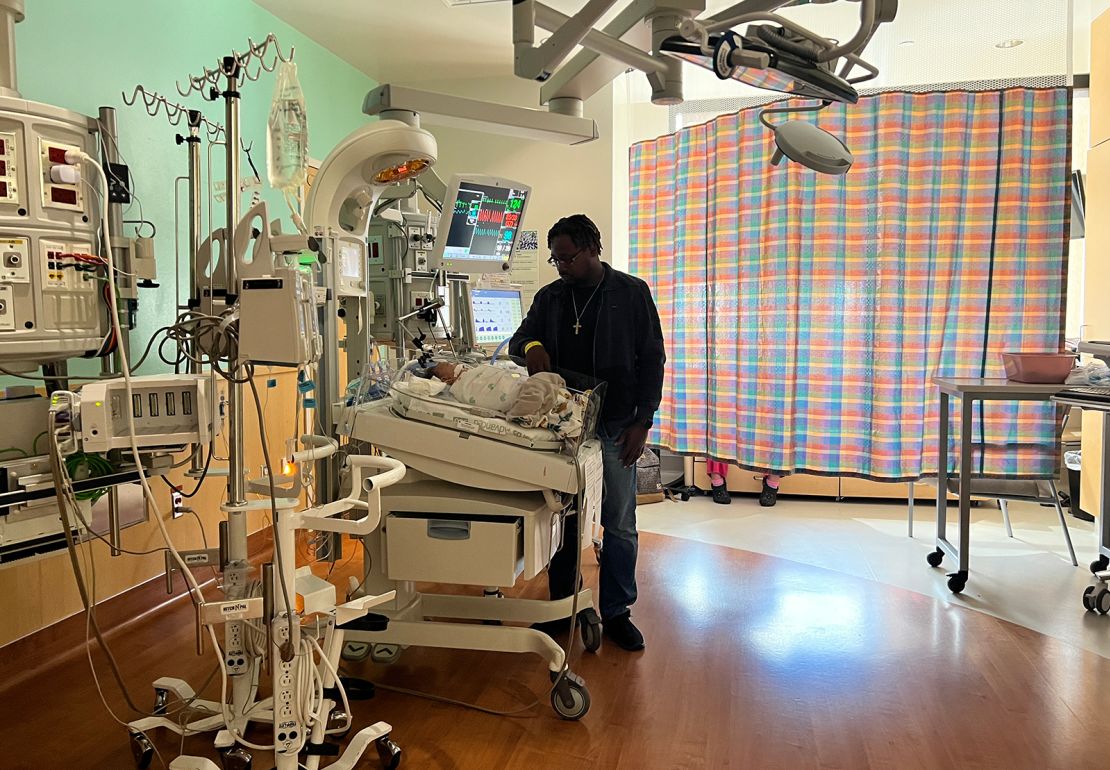 Stephen Balka stands over his son Adrian, who is hospitalized at Texas Children's Hospital with RSV.