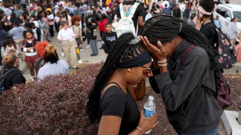 Students cry near Central Visual and Performing Arts High School, where two people were killed.