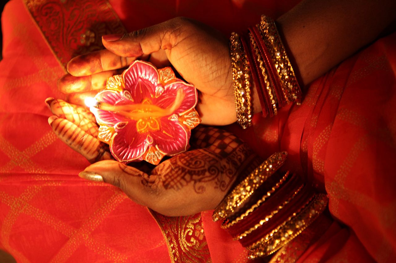 A Hindu devotee holds a flower-shaped candle called a diya at a temple in Toronto on Monday.