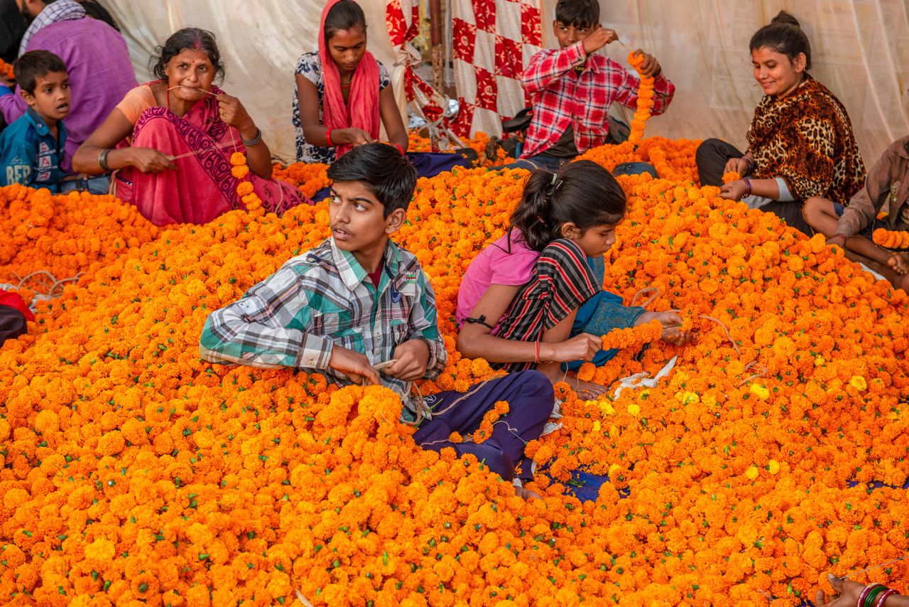 People prepare marigold garlands for Diwali at a flower market in New Delhi.