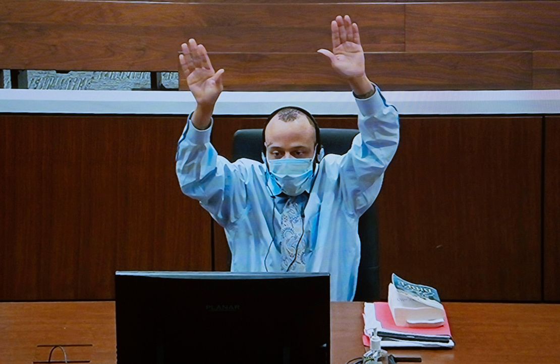 Darrell Brooks attempts to get the court's attention as he appears via video from an adjacent courtroom due to his continuous interruptions of the court judge during his trial Tuesday, October 25, 2022.