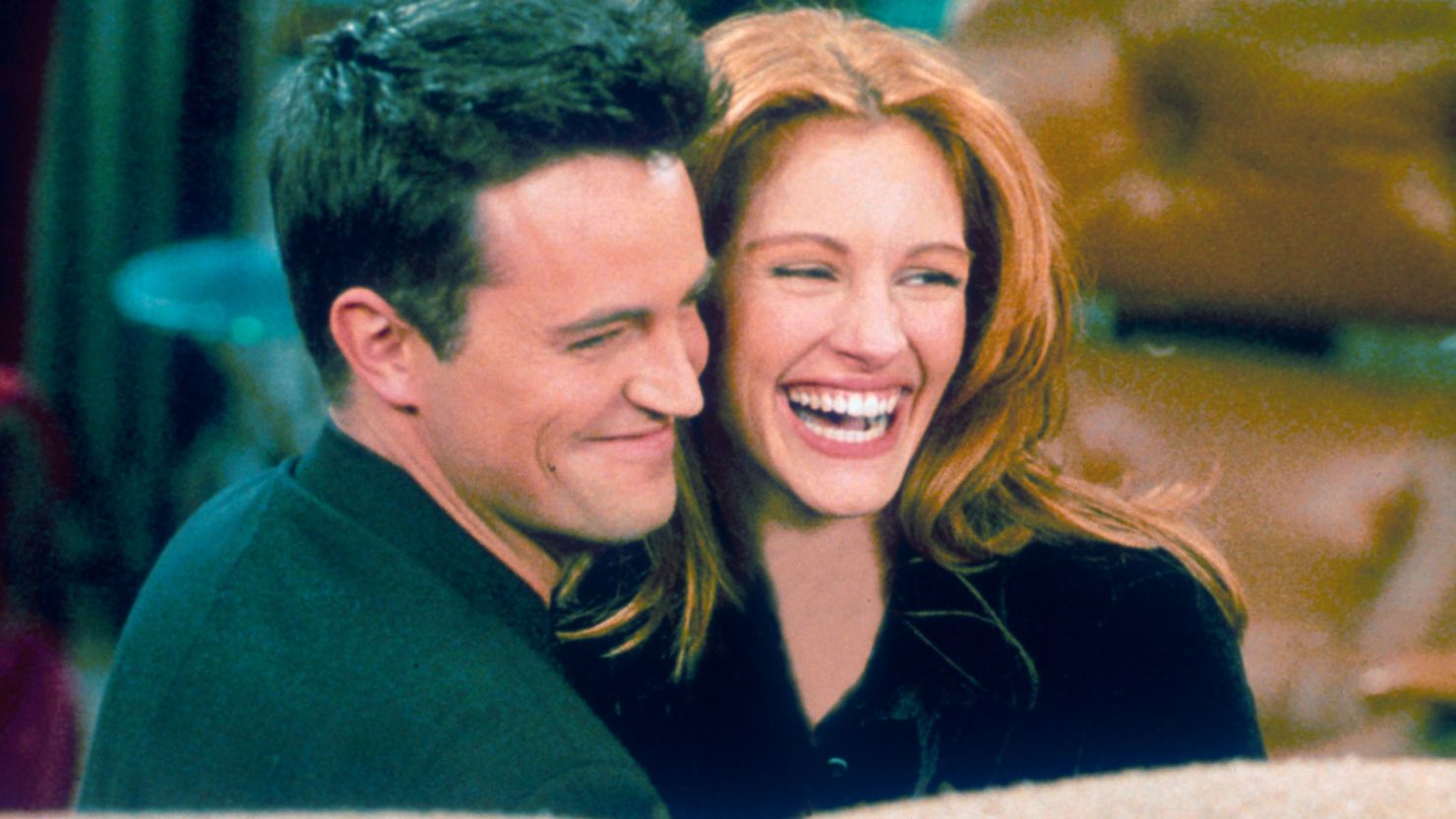Matthew Perry and actress Julia Roberts hug each other on the set of "Friends" in 1996.