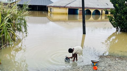 A child is pictured doing her dishes in floodwater in Odi, in Nigeria's southern Bayelsa State, on Tuesday.