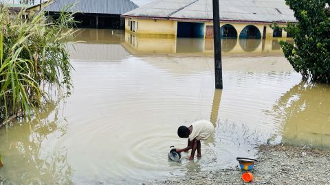 Seorang anak digambarkan sedang mencuci piring di air banjir di Odi, di Negara Bagian Bayelsa selatan Nigeria, pada hari Selasa.