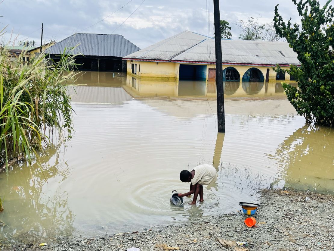 A child is pictured doing her dishes in floodwater in Odi, in Nigeria's southern Bayelsa State, on Tuesday.