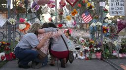 Shari Unger, Melissa Goldsmith and Giulianna Cerbono (L-R) hug each other as they visit a makeshift memorial setup in front of Marjory Stoneman Douglas High School on February 18, 2018 in Parkland, Florida. Police arrested and charged 19 year old former student Nikolas Cruz for the February 14 shooting that killed 17 people. 