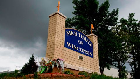 Memorial flowers adorn the sign of the Sikh temple in suburban Milwaukee where six members were fatally shot by a white supremacist in August 2012.
