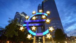The large euro symbol in front of the former headquarters of the European Central Bank (ECB, r) glows in the early morning. 