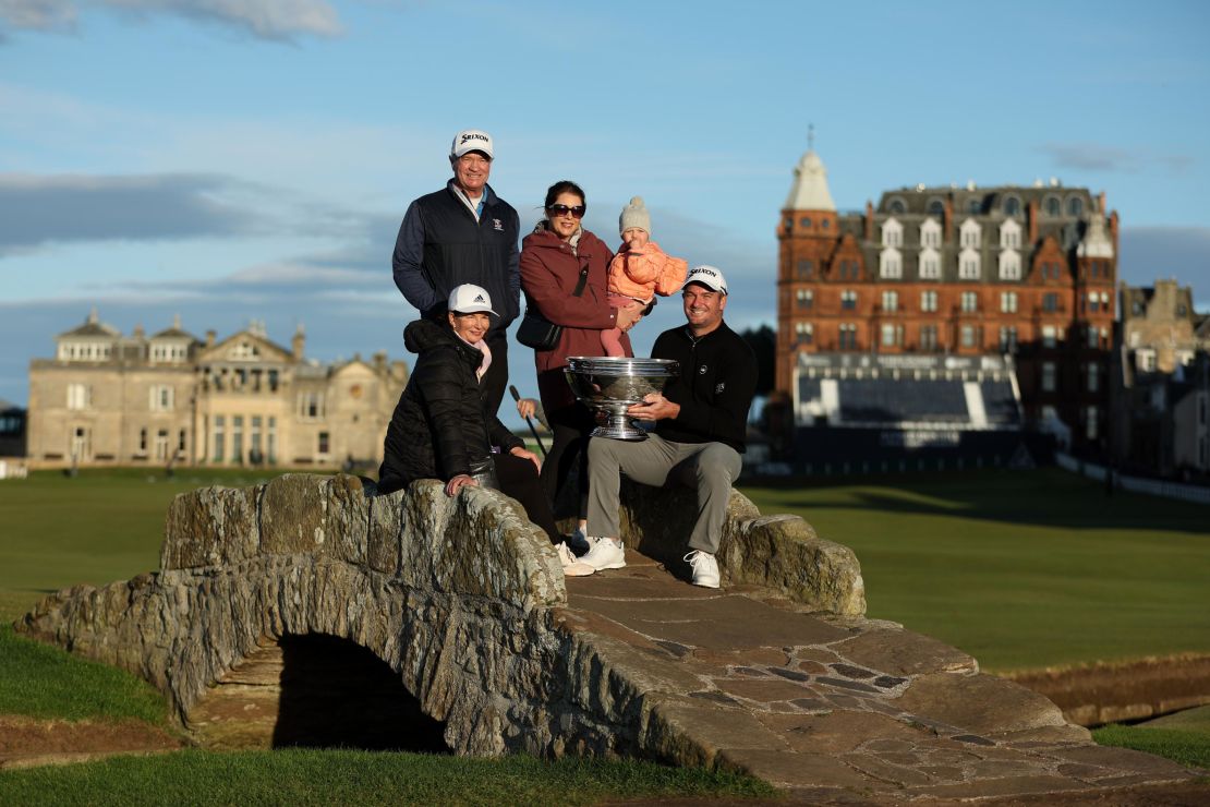Fox poses with the Alfred Dunhill Links Championship trophy with mother Adele Fox, father Grant Fox, wife Anneke Fox and their daughter Isabel Fox on the Swilcan Bridge at St. Andrews.