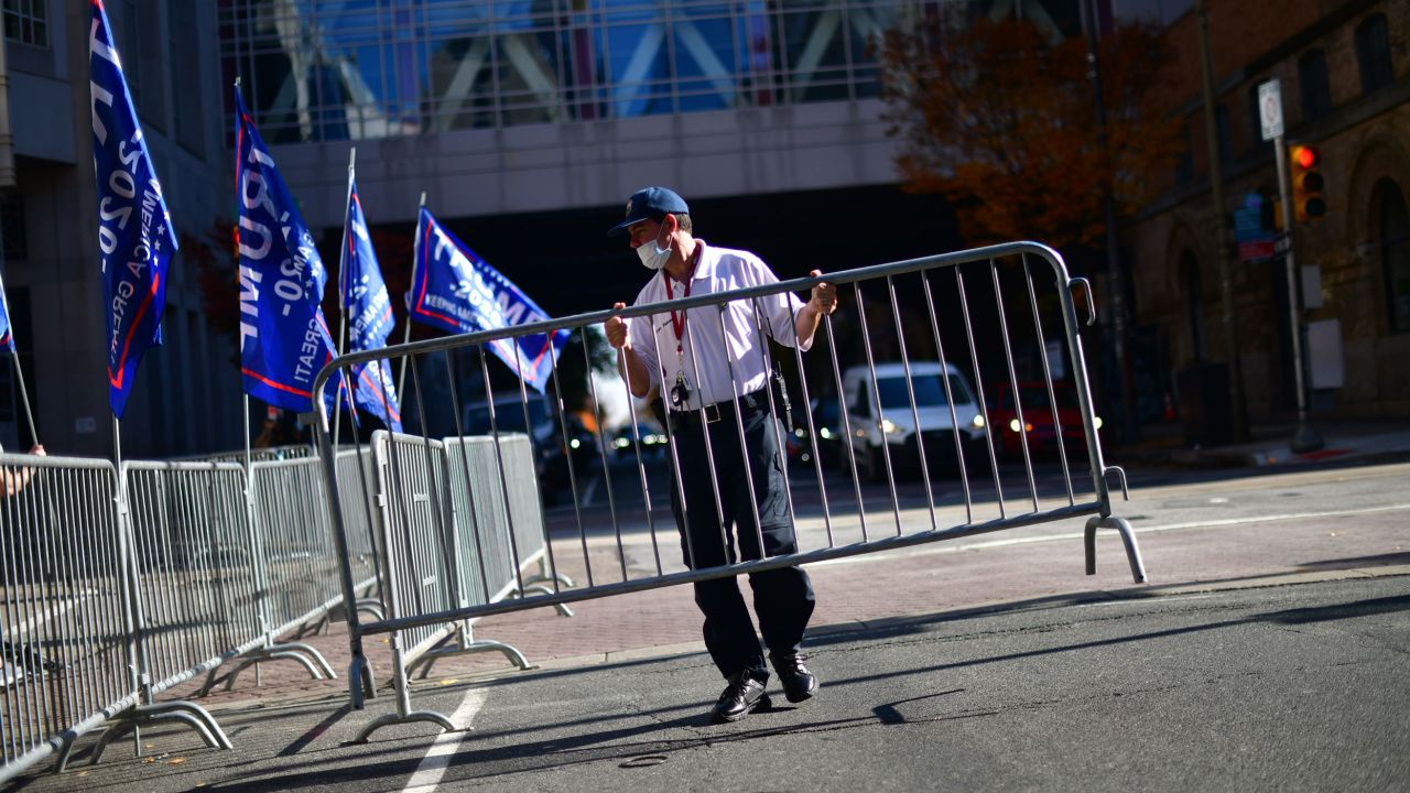 A security guard sets up a barricade in front of a designated demonstration area for supporters of President Donald Trump outside of where votes were still being counted, six days after the election on November 9, 2020 in Philadelphia