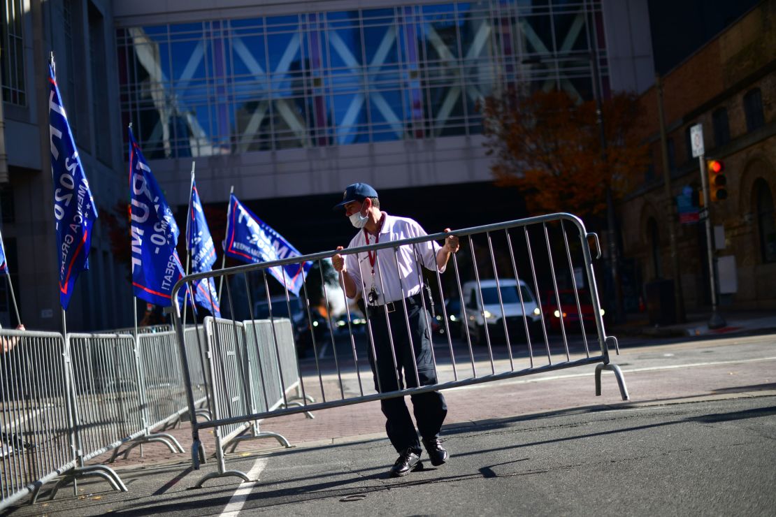 A security guard sets up a barricade in front of a designated demonstration area for supporters of President Donald Trump outside of where votes were still being counted, six days after the election on November 9, 2020 in Philadelphia