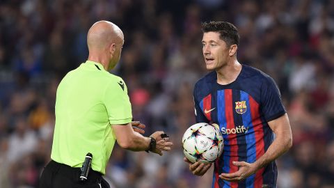 Barcelona forward Lewandowski (R) argues with English referee Anthony Taylor during the game against Bayern.