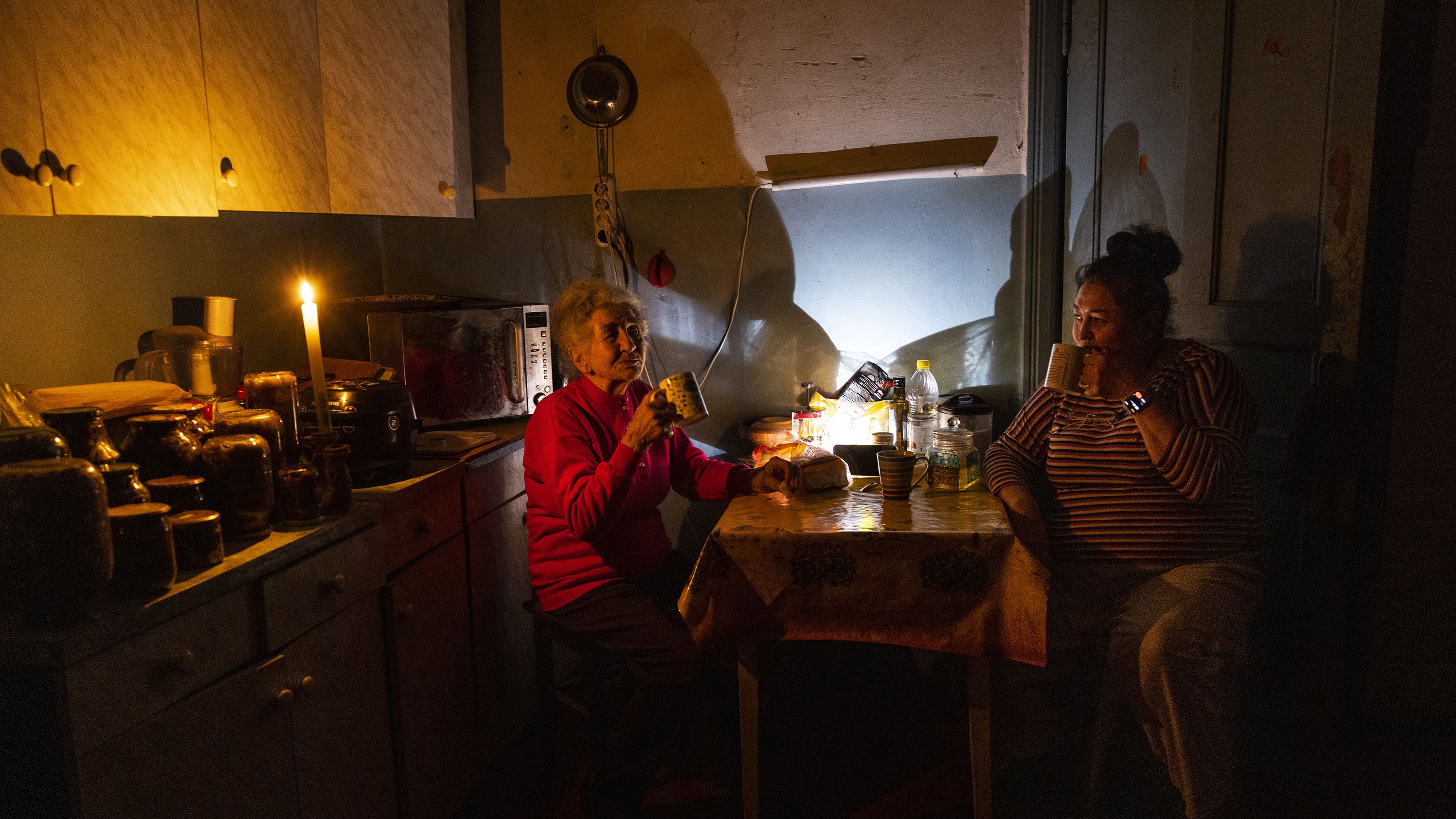 Natalia Zemko, 81, talks with her daughter Lesya as they drink tea in their kitchen during a power outage in downtown Kyiv on October 22.