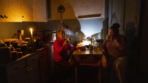 Natalia Zemko, 81, is drinking tea in her kitchen and talking to her daughter Lesha during a power outage in downtown Kyiv on October 22.
