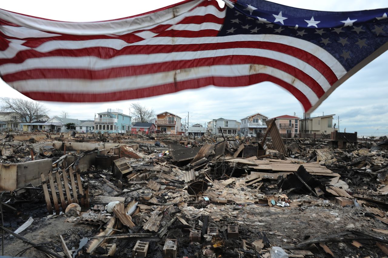 An American flag flies above burned-out homes in the Breezy Point neighborhood of Queens, New York, on November 1, 2012. More than 100 homes were destroyed by a fire during Superstorm Sandy.