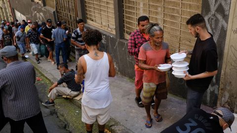 Hundreds of people line up for a meal at a soup kitchen in downtown São Paulo.