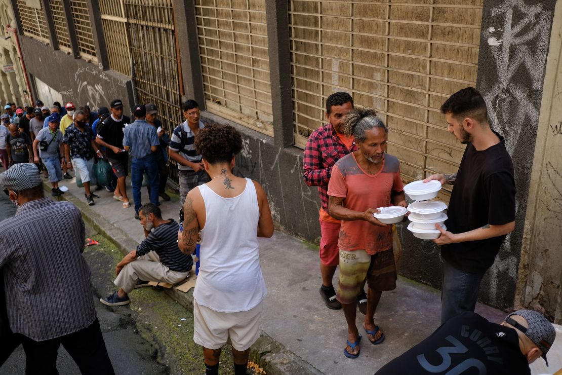Hundreds of people line up for a meal at a soup kitchen in downtown São Paulo.